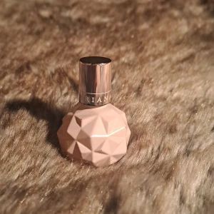 Parfym i geometrisk flaska - Säljer en parfym från Ariana Grande i en unik geometrisk flaska. Flaskan är ljusrosa med en silverfärgad kork. Perfekt för den som älskar stilfulla och moderna designinslag i sin parfymkollektion.