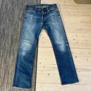 Blå vintage jeans från Levi's - Säljer ett par klassiska blå Levi's jeans med en straight passform. De har en snygg slitning och fem fickor. Perfekta för en avslappnad stil. Storlek 32/32 men passar mer som 30/32 kanske. Har nämligen runt 32/32 och dessa är för små i lår och midja.