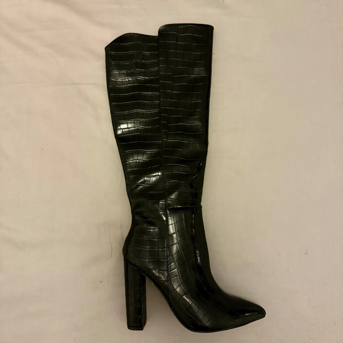 Svarta stövlar med krokodilmönster