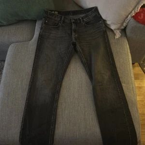 Svarta jeansbyxor från gstar - Snygga svarta jeansbyxor från gstar med klassisk femficksdesign. Byxorna har en rak passform och stängs med dragkedja och knapp. Perfekta för en stilren look.