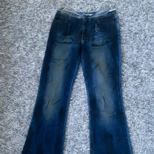 Lågmidjade jeans  -  Coola lågmidjade jeans utan fickor. Finns bild på men de är lite försmå på modellen (bilden med byxorna på har skärp men det har inte dessa). Midjemått: ca 35 cm, ytterbenslängden ca 97 cm.☺️bootcut