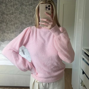 Rosa stickad tröja - Mysig rosa stickad tröja med puffiga långa ärmar och ribbade muddar. Perfekt för kyligare dagar och ger en söt touch till din outfit.