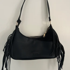 Väska med fransdetaljer - Liten axelväska. Sparsamt använd