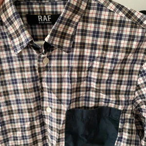 Raf Simons skjorta - En knapp borta på ena armen men ser snyggt ut om du har båda armarna uppknäppta! Size S. Inga andra defekter!