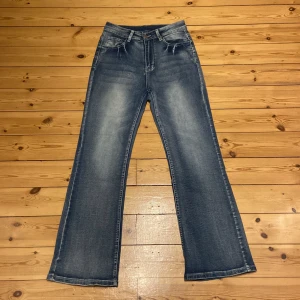 Blå jeans med broderade fickor - Säljer ett par snygga blå jeans med coola broderade detaljer på bakfickorna. De har en klassisk femficksdesign och en skön passform och bootcut. Helt nya! Har inte använt dom! 
