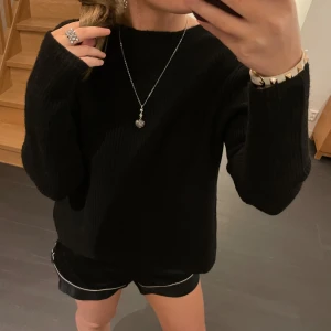 Svart stickad tröja med knytning - Säljer en superfin svart stickad tröja med knytning i ryggen. Den har en öppen rygg och långa ärmar. Man kan ha rosetterna antingen framtill eller bak om man vill ha öppen rygg☺️Aldrig använd då den är lite för stor💕