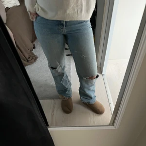 Ljusa jeans med slitningar - Säljer ett par ljusa jeans i bra skick med slitningar på knäna. De är raka och Midwaist. 