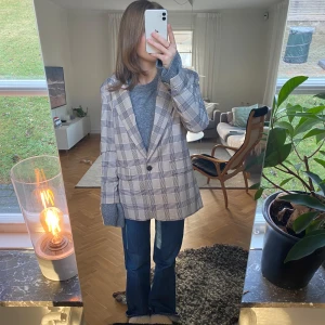 Rutig kavaj i beige och grå - Säljer en snygg rutig kavaj i beige och grå toner. Den har en klassisk passform med knappar framtill och långa ärmar. Perfekt för höst och vår, och funkar både till vardags och fest. Passar bra över en stickad tröja för en stilren look 🩶🤍 