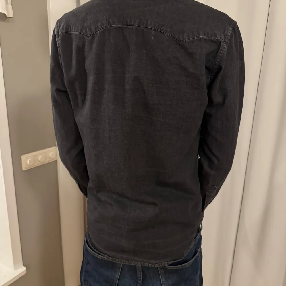 Säljer en snygg svart jeansskjorta från Levi's i storlek S. Skjortan har långa ärmar och knappar framtill, samt två bröstfickor med lock. Perfekt för en casual look eller en utekväll. Passar bra till både jeans och chinos. 🖤. Skjortor.