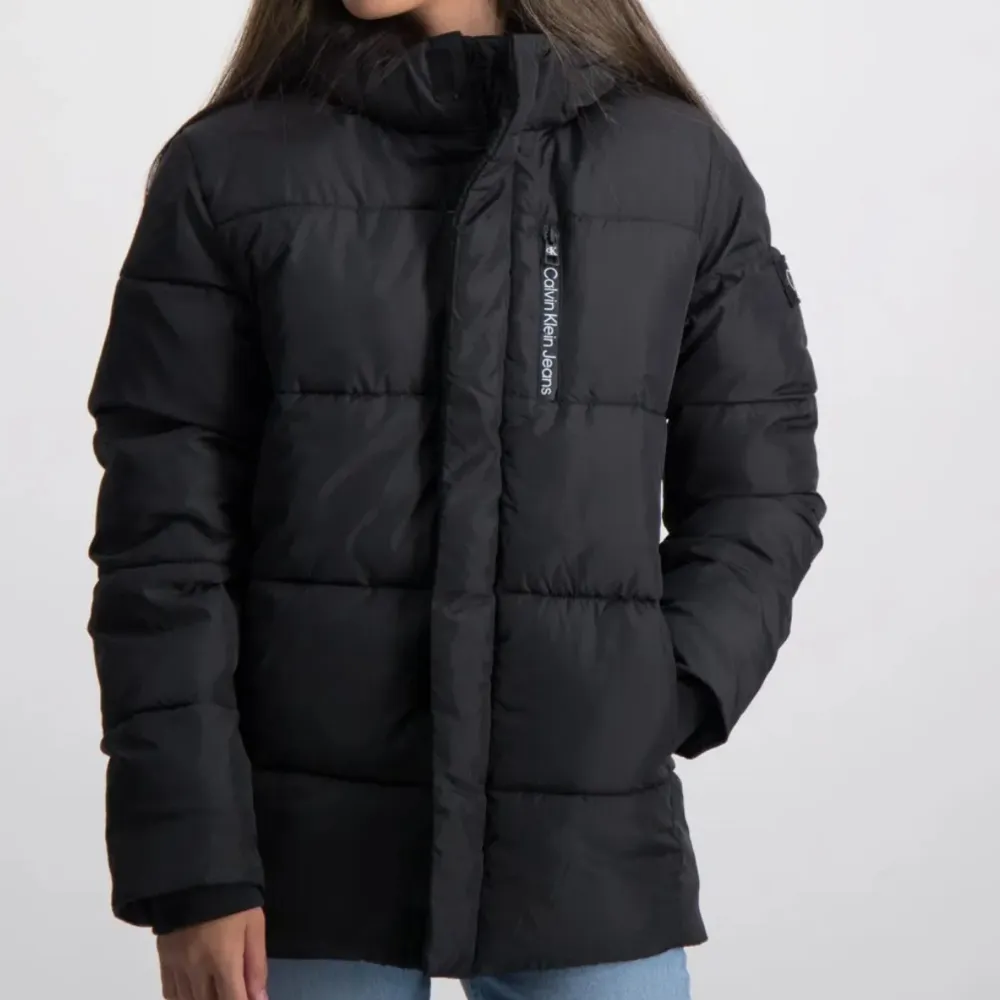 Säljer en snygg svart pufferjacka från Calvin Klein. Jackan är perfekt för kalla dagar med sin vadderade design och långa ärmar. Den har en dragkedja framtill och märkeslogga på bröstet och ärmen. Superbekväm och stilren för både höst och vinter! Jag köpte jackan för 1800kr. . Takit.
