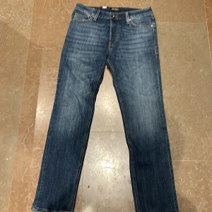 Blå jeans från Jack & Jones - Säljer ett par snygga blå jeans från Jack & Jones i modellen Slim Straight Tim. De har en regular rise och slim fit vid lår och knä.🤩