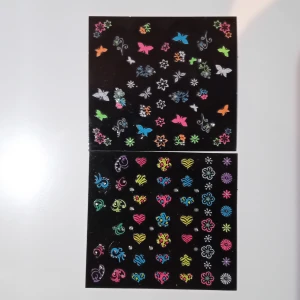 Nagel klistermärken - Färgglada nagelklistermärken med olika mönster som fjärilar, blommor, hjärtan och havsmotiv. Perfekt för att dekorera naglarna med en personlig touch. Innehåller även eleganta mönster i svart och silver. Saknar några klistermärken från de olika arken