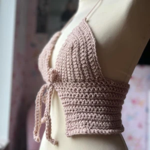 Beige virkad topp - Snygg beige virkad topp med knytning fram. Perfekt för sommardagar eller festivaler. Den är croppad och har en ribbad design som ger en trendig look. Passar bra till både jeans och kjol!