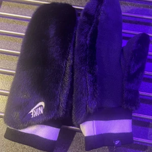 Svarta handskar från Nike oanvända  - Säljer ett par svarta handskar från Nike i nytt skick. De är mjuka och varma, perfekta för vintern. Handskarna har en vit Nike-logga och ribbstickade muddar i svart och vitt. Perfekta för att hålla händerna varma under kalla dagar!