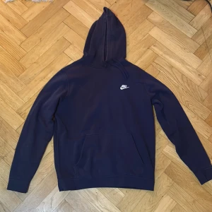 Mörkblå hoodie från Nike - Säljer en snygg och bekväm mörkblå hoodie från Nike. Perfekt för kyliga dagar med sin mjuka insida och klassiska design. Den har en känguruficka och justerbar huva. Passar både till vardags och träning. 🌀