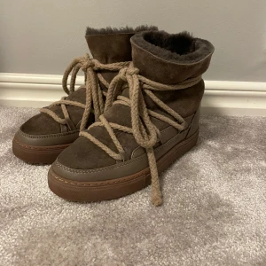 Bruna inuikiis🤎🤎🤎 - Säljer ett par snygga bruna inuikii i mocka med mysigt foder. De har en cool snörning som ger en unik look och är perfekta för kalla dagar. Bootsens höga skaft håller värmen och de är i bra skick. Perfekta för vinterns äventyr!