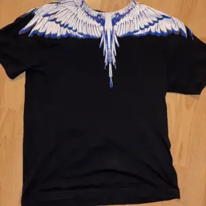 Säljer en svart t-shirt från Marcelo Burlon i storlek xs. Perfekt för en unik och stilren look. T-shirten är i bomull och har korta ärmar. Storleken är xs men jag skulle säga att den passar small och medium då den är rätt stor. 