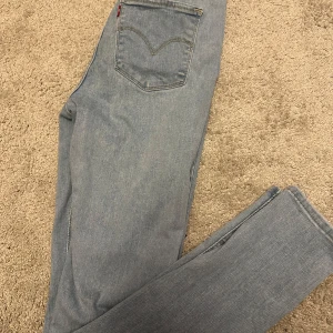 Levi's 720 High-Rise Super Skinny Jeans - Säljer ett par ljusblå Levi's 720 High-Rise Super Skinny jeans i mycket bra skick. De är högmidjade och har en tight passform som sitter perfekt. Klassisk Levi's-design med den ikoniska läderpatchen och röda etiketten på bakfickan. Perfekta för både vardag och fest!