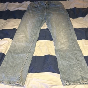 Ljusblå jeansbyxor - Säljer ett par ljusblå jeansbyxor i bra skick. De har en klassisk straight passform och är perfekta för vardagsbruk. Byxorna har en midwaist och är tillverkade i jeansmaterial. Perfekta för både vår och höst! Tvättas innan