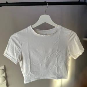 Två croppade t-shirts i vitt och beige - Två croppade t-shirts i vitt och beige från Lager157. Säljer båda i ett kit. Otroligt skönt material. Köpta för 80kr/st, säljer båda för 100kr