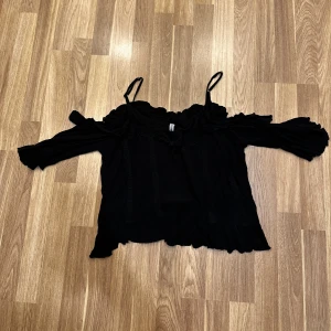 Svart offshoulder topp - Snygg svart offshoulder topp med smala axelband och trekvartsärmar från New Yorker i storlek M!. Perfekt för en kväll ute eller en sommarfest. Den är superbekväm att bära. Oanvänd!