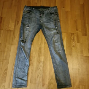 Blå jeans från Dsquared2 - Storlek M/L men passar även XL. Det står 52 under Dsquared2 märket inuti byxorna så jag gissar på att det är storlek 52. Helt nya och bara andvända 1 gång. Säljer ett par snygga blå jeans från Dsquared2 i bra skick. De har en cool slitningseffekt.Jeansen har en knappgylf och klassisk femficksdesign. Skika och fråga om bättre bilder om de skulle vara så att du vill ha och jag kan ändra på priset.