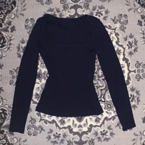 Mörkblå långärmad topp - Säljer en stilren mörkblå långärmad topp i mycket bra skick. Den har en tight passform. Toppen är enkel men jättefin och kan matchas med nästan vad som helst :)