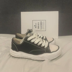 Svarta sneakers från Maison Mihara Yasuhiro - Säljer ett par snygga svarta sneakers från Maison Mihara Yasuhiro. Skorna är i mycket bra skick och kommer i originalförpackning. Thriftade de så vet inte om de är äkta. Sitter som 44,5