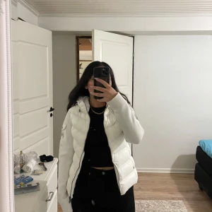 Vit dunjacka från Moncler - Säljer en snygg vit pufferjacka från Moncler i storlek S. Jackan är perfekt för vintern/hösten men även våren med sitt varma och vadderade material. Den har en dragkedja framtill och två fickor med knappar. Jackan är i nyskick och har en normal passform. Perfekt för att hålla dig varm och stilren under kalla dagar! Säljer den då den blivit för liten för mig. Jättebra skick och mycket fin, inga sminkfläckar elle annat dåligt! Vid fler bilder eller frågor är de bara att skriva