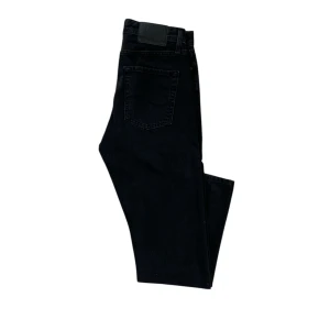 Svarta jeans i loose fit - Säljer ett par svarta jeans i loose fit, modell Chris. Perfekta för en avslappnad stil och passar till de flesta tillfällen. De har en klassisk femficksdesign och är i bra skick. Perfekta för både vardag och fest!