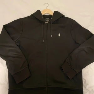 Ralph lauren zip hoodie  - Säljer en svart zip hoddie från Ralph Lauren som är i mycket bra skick. Den är inte använd särkilt mycket. Storlek M. Nypris 2300, mitt pris 1000. Hör av er för fler bilder eller vid funderingar!