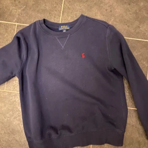 Mörkblå tröja från Polo Ralph Lauren - Säljer en snygg mörkblå tröja från Polo Ralph Lauren i storlek 158. Hör av er vid intresse eller om ni vill se fler bilder!