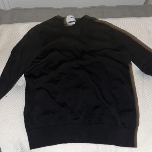 Svart ulltröja från NN07 - Säljer en stilren svart tröja från NN07, tillverkad av 100% ull. Perfekt för kyligare dagar med sin mjuka och varma känsla. Tröjan har en klassisk design med rund hals och långa ärmar. Ett måste i garderoben för den som gillar enkel och tidlös stil. Det var min pappas innan men den krypte så den passar 146-152 