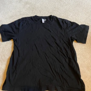 Svart t-shirt från H&M Divided - Säljer en klassisk svart t-shirt från H&M Divided. Den har en enkel design med korta ärmar och rund hals 💞