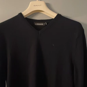 Mörkblå från J.Lindeberg - Snygg svart tröja från J.Lindeberg med v-ringad hals. Perfekt för en stilren look. Tröjan har långa ärmar och är tillverkad i ett mjukt material för extra komfort. Helt ny hör av er vid funderingar !!!