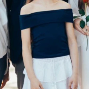 Mörkblå offshoulder topp - Säljer en stilren mörkblå offshoulder topp. Perfekt för en elegant och avslappnad look. Toppen är i ett mjukt och bekvämt material som sitter snyggt på kroppen.
