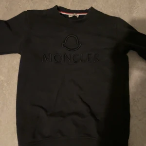 Svart sweatshirt från Moncler - Säljer en stilren svart sweatshirt från Moncler med broderad logga på bröstet. Tröjan har långa ärmar och en rund halsringning.För mer bilder skriv privat.                                                Pris kan diskuteras!!