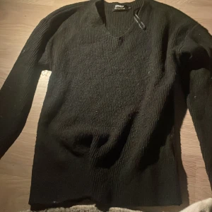 Svart ribbad tröja från Only(priset kan budas ner) - Säljer en stilren svart ribbad tröja från Only. Tröjan har en v-ringad hals och långa ärmar, perfekt för våren. Den är både bekväm och lätt att matcha med olika outfits. 