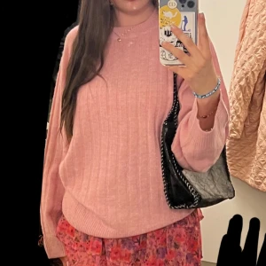 Rosa stickad tröja - Säljer en söt rosa stickad tröja med ribbade detaljer. Tröjan har långa ärmar och en avslappnad passform!
