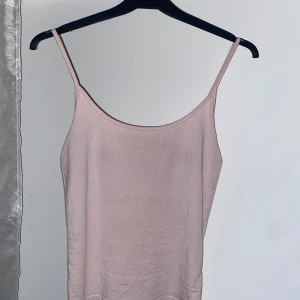 Ljusrosa linnetopp från Gina Tricot - Säljer ett ljusrosa linne från Gina Tricot. Perfekt för sommardagar med sin enkla och stilrena design. Toppen har smala axelband och är tillverkad i ett mjukt material.