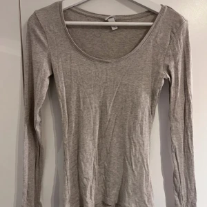  Långärmad topp - Säljer en beige/grå ribbad långärmad topp från H&M. 