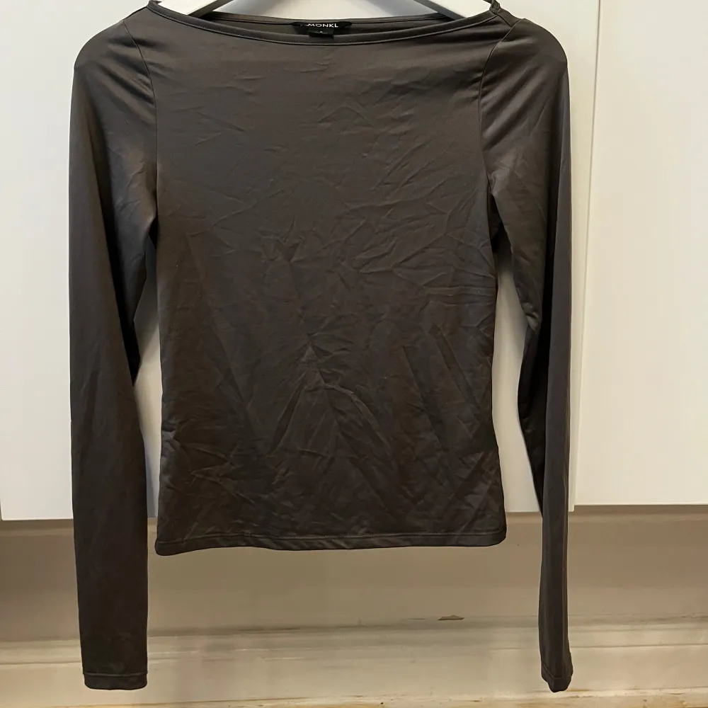 Snygg grå boatneck topp. Perfekt för en stilren look. Tillverkad i ett mjukt och bekvämt material som passar bra till olika outfits.. Neuletakit & Villapaidat.