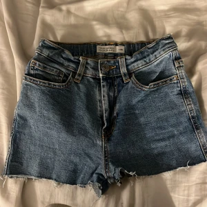 Blå jeansshorts från Cubus - Snygga blå jeansshorts med fransiga kanter från Cubus. De har en klassisk femficksdesign och knappgylf. Perfekta för en avslappnad stil. Shortsen används inte då de inte passar💗