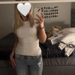 Vit kortärmad topp - Säljer en jättemjuk vit kortärmad topp med rund hals. Perfekt basplagg som passar till det mesta. Har både klätt upp och klätt ner denna! Från Nelly.com och säljer då jag har 2 likadana💕Nypris 250kr. Använd ett fåtal gånger🫶🏼