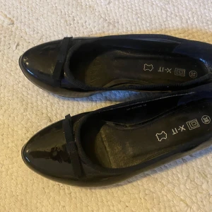 Svarta ballerinaskor med rosett - Jättesöta ballerina skor från X-IT. Köpta från second hand men är i bra skick. Säljer så de tyvär inte passar mig. Kontakta vid intresse eller fler frågor.🩷.           tar Swish. TRYCK EJ PÅ KÖP NU