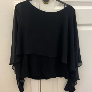 Svart blus från Zara Woman - Elegant svart blus från Zara Woman med flödande design och långa ärmar. Aldrig använd 💗