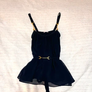 Mörkblå topp från Ida Sjöstedt - Mörkblå topp med gudldetaljer från Ida Sjöstedt. Knyte där bak 