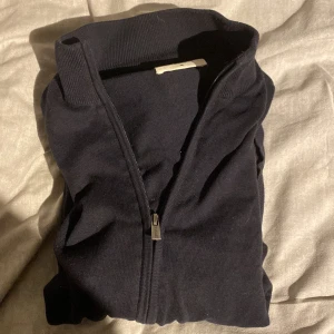 Hel zip tröja - Säljer en stilren mörkblå kofta från Cortefiel i storlek M men sitter mer som en S. Koftan har en hel dragkedja. Perfekt för lager-på-lager under kyligare dagar.