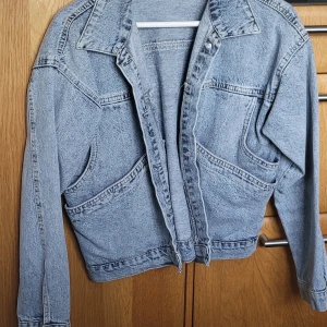 Ljusblå jeansjacka - Säljer en klassisk ljusblå jeansjacka med normal passform. Jackan har långa ärmar och knappar framtill. 