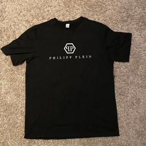 Philipp Plein T-shirt   - Snygg svart t-shirt från Philipp Plein med vit logga på. .                                                                                       Har ingen philipp plein tag                                                       